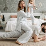 A cheerful family enjoys bonding and playing together on a cozy morning in a stylish bedroom.