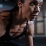 Close-up of a determined female athlete sweating during a workout session indoors.